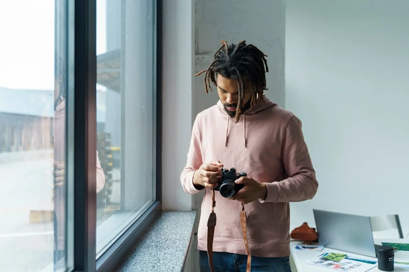 Un hombre observa su cámara.